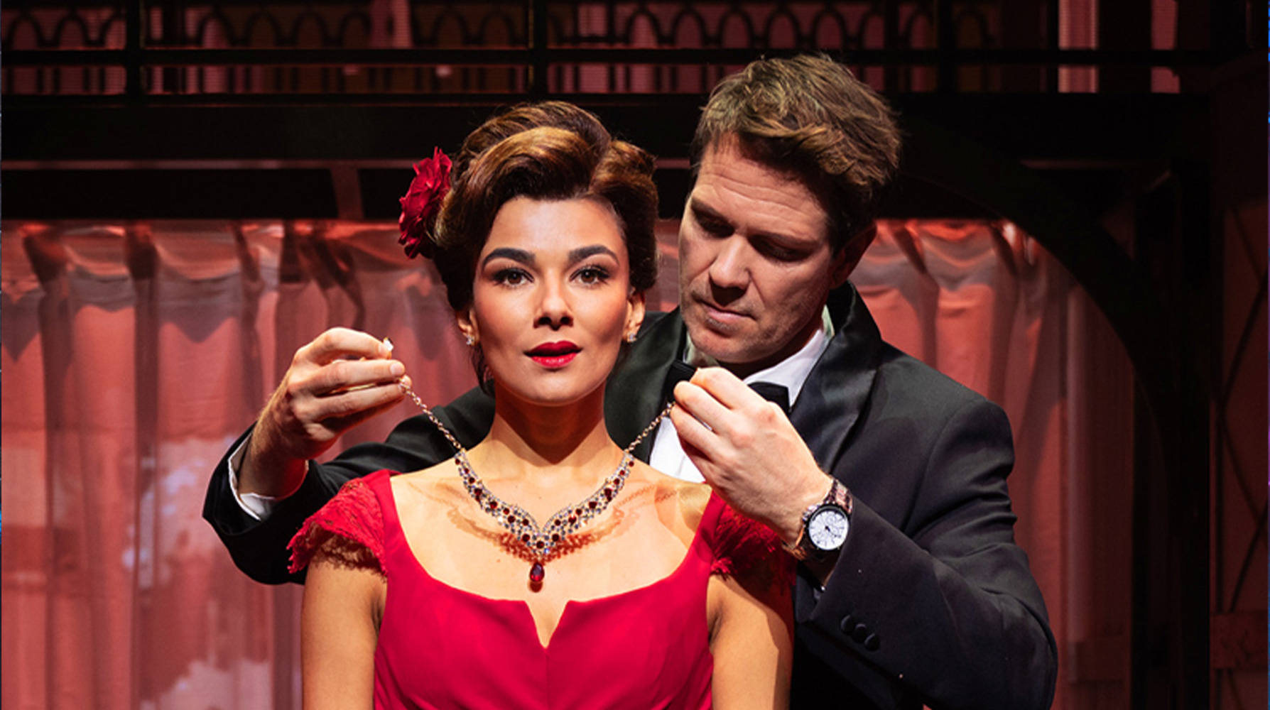 Elegantes Paar mit Halskette auf roter Bühne