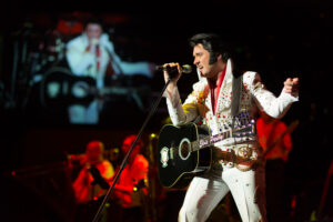 Elvis-Imitator singt und spielt Gitarre auf Bühne