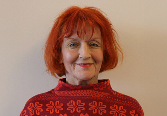 Frau mit rotem Haar, rotem Pullover, lächelt